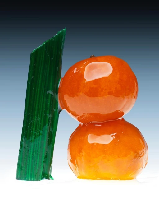 Two mandarin oranges stacked with a green rock candy stick, against a graduated blue-to-white background, studio lighting, and food photography.