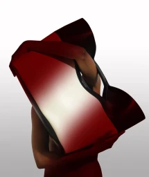 Person holding a large red and white gradient tote bag obscuring their head against a light background