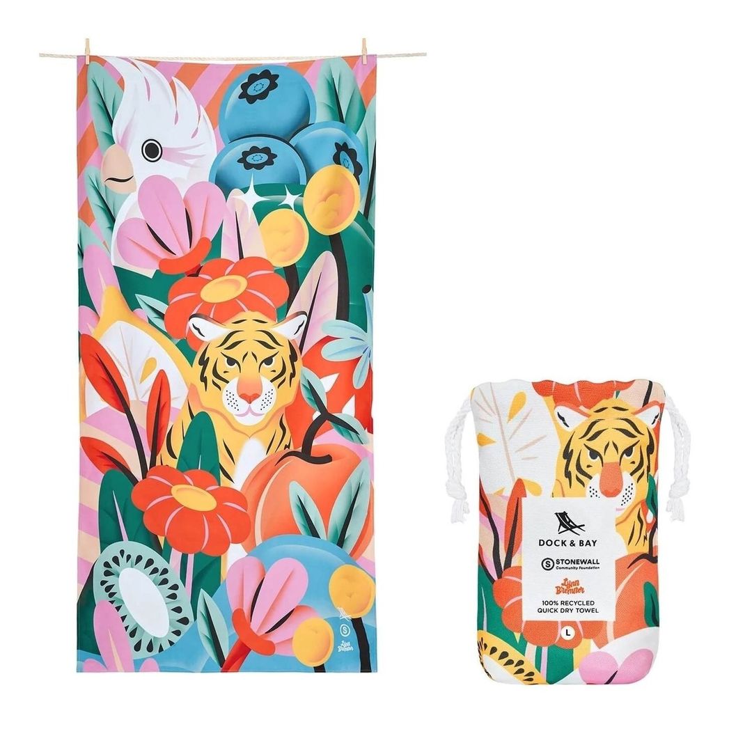 Vibrant beach towel and matching drawstring bag featuring a stylized tiger, parrot, flowers, and fruits on a white background.