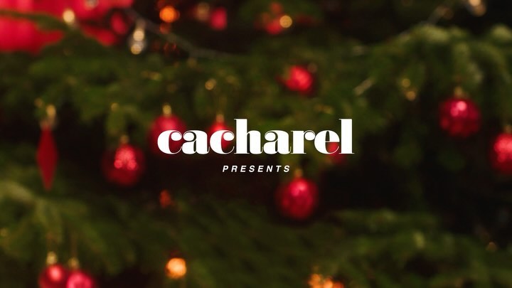 Christmas tree decorated with red ornaments, soft focus background, featuring 'Cacharel Presents' text overlay for holiday design.