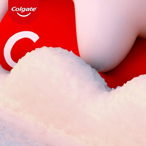A close-up digital rendering features a Colgate logo atop white crystalline structures against a bold red background. 