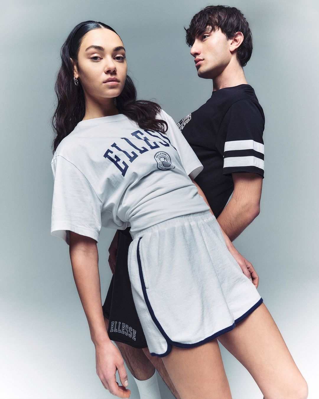 Two models posing against a neutral grey studio backdrop wearing sportswear by photographer Mads Perch