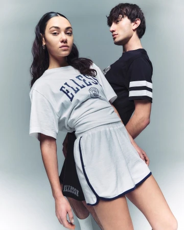 Two models posing against a neutral grey studio backdrop wearing sportswear by photographer Mads Perch