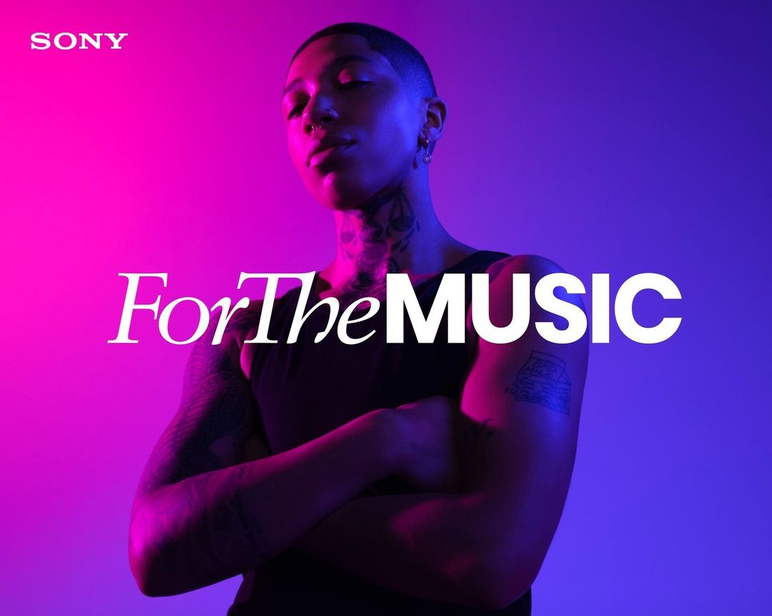 Close-up of a person with crossed arms against a vivid pink and blue background, promoting Sony's focus on music experience.