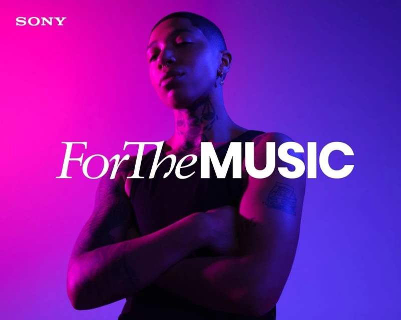 Close-up of a person with crossed arms against a vivid pink and blue background, promoting Sony's focus on music experience.