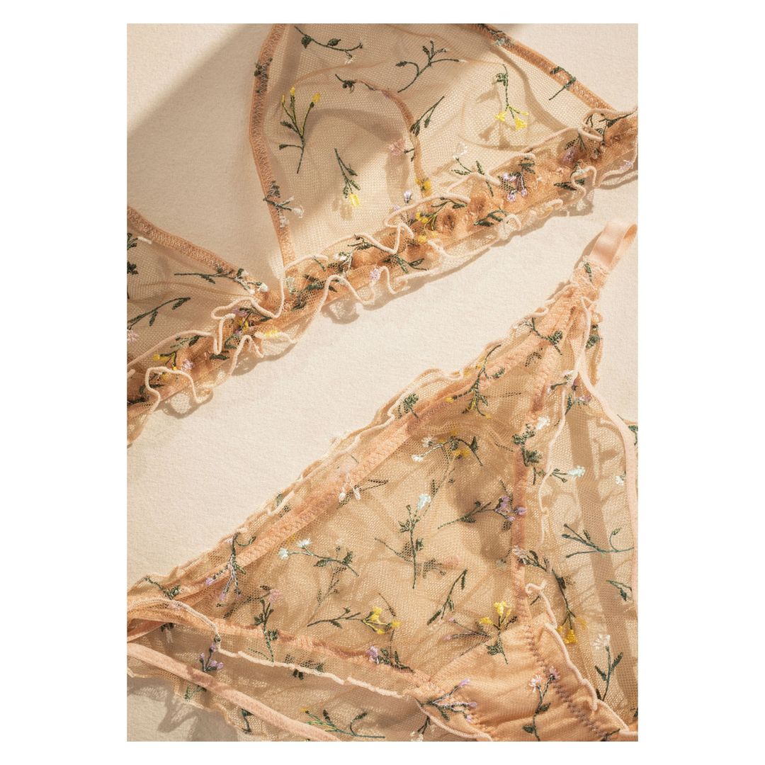 Floral embroidered lingerie set featuring a bralette and bottoms, with soft lighting highlighting the intricate details of the design.