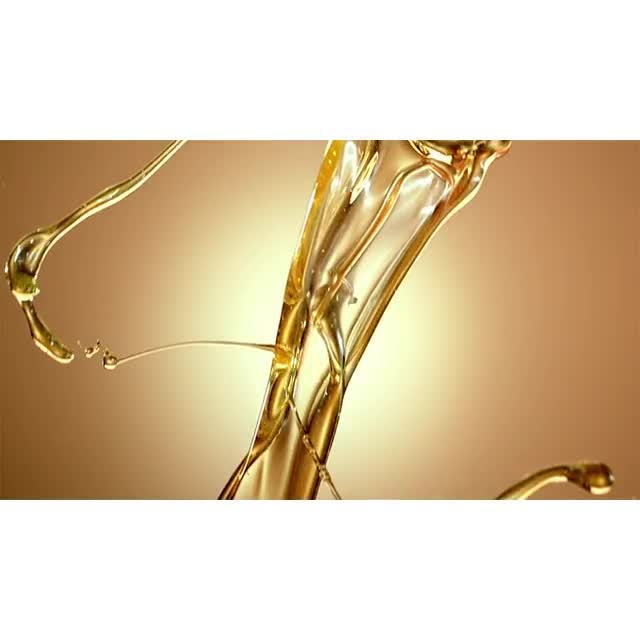 Golden liquid, possibly oil or syrup, in motion against a warm golden background, creating an abstract and dynamic visual composition.