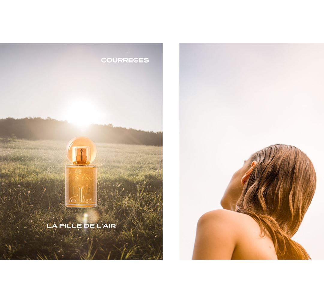 Courreges perfume bottle in a field, product shot for beauty advertisement. Light skin adult looks up to the sky. Bright, sunny outdoor setting.