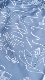 Close-up of blue fabric with a white abstract line drawing pattern featuring a stitched back pocket.