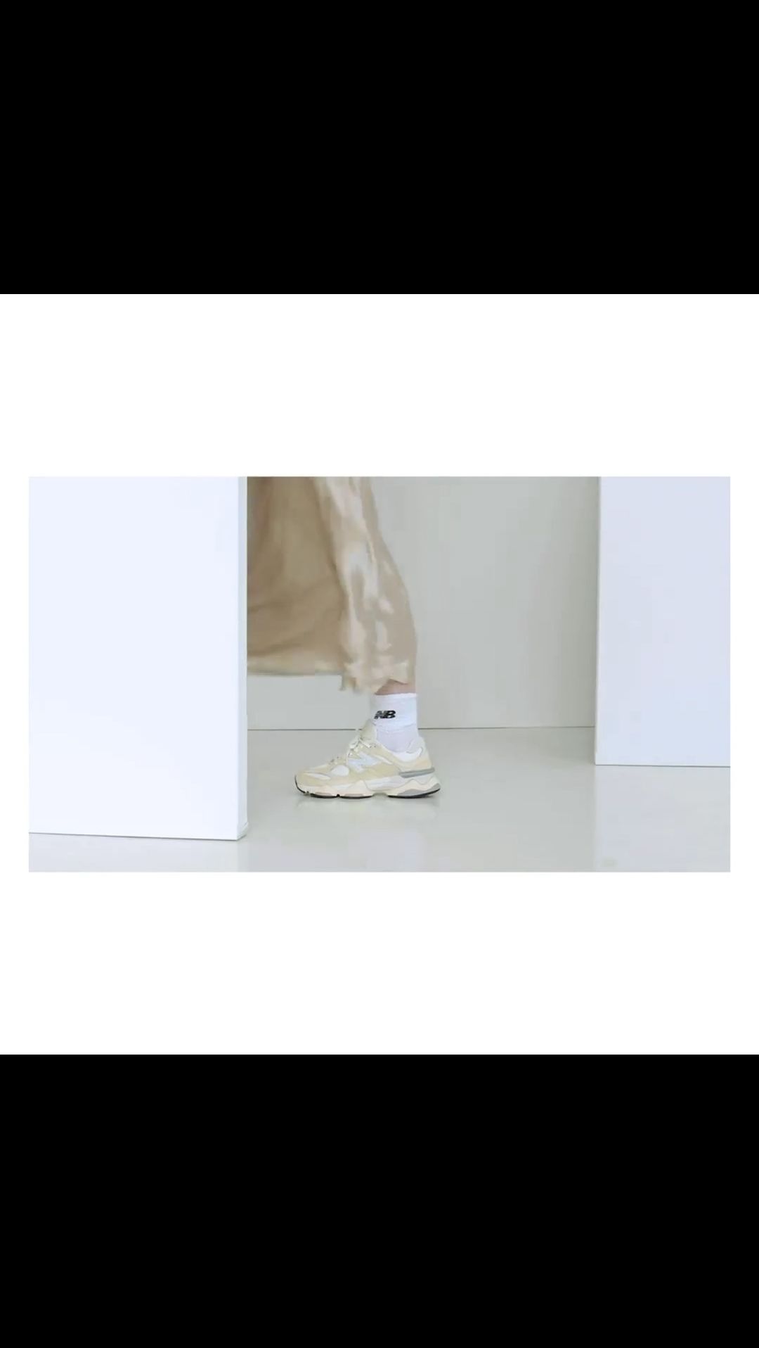 Beige New Balance sneakers and white socks are showcased against a clean white backdrop, embodying minimalist fashion.
