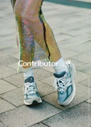 Close-up of legs wearing white socks, New Balance sneakers, and a shimmering metallic mesh skirt outdoors.