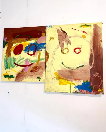 Two abstract, colorful, childlike paintings of smiley faces. One with a brown background and one with a yellow background, indoor studio shot.