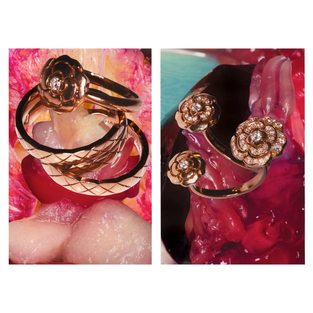 Close-up of three gold flower-shaped rings with diamond accents, arranged on a colorful textured surface in a studio setting.