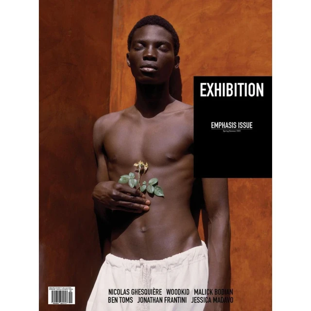Magazine cover featuring a young adult man with dark skin holding a flower against an orange wall with black text overlay and a list of names.