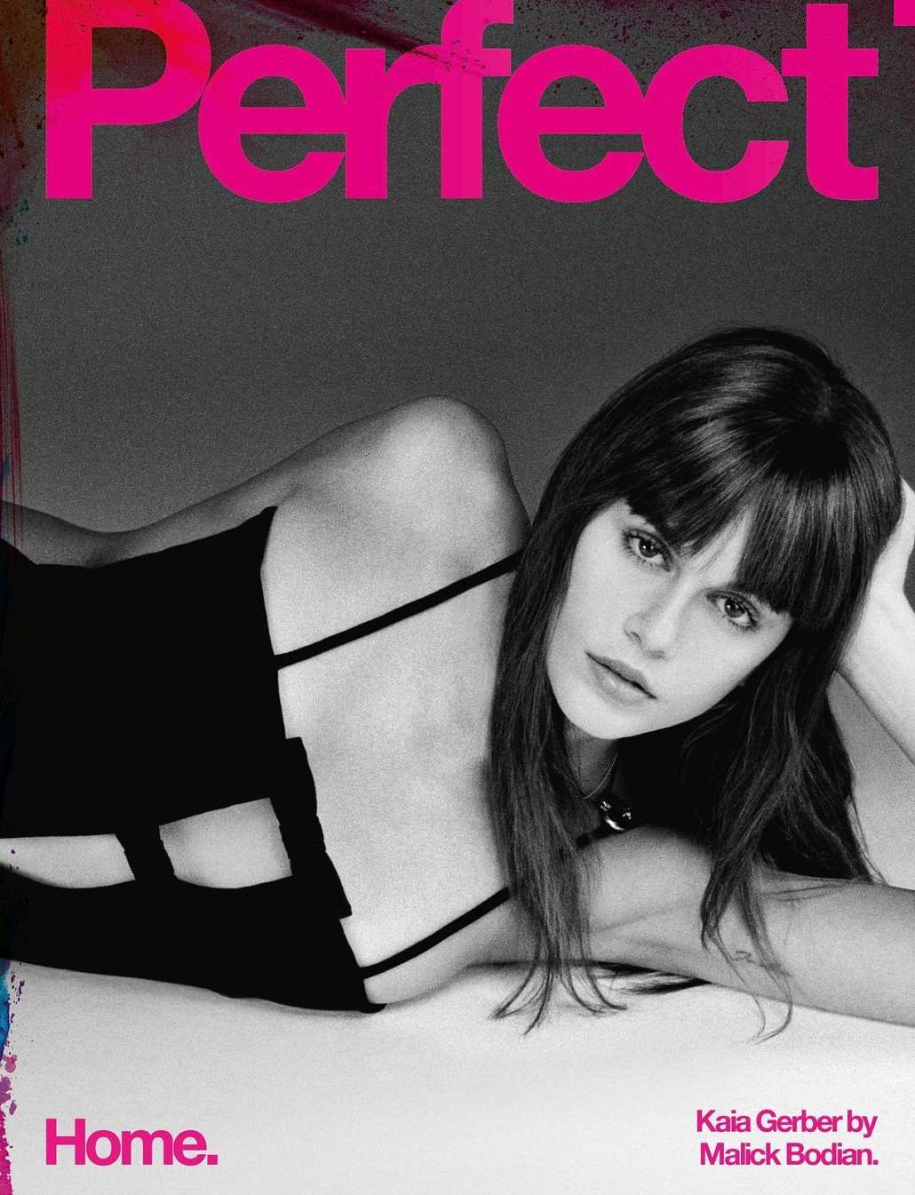 Black and white portrait of Kaia Gerber lying down while wearing a black top, shot for Perfect Magazine.
