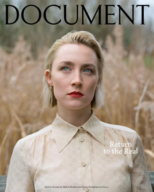 Close-up magazine cover shot of Saoirse Ronan with blonde hair and red lipstick wearing a Gucci collared shirt standing in a field.