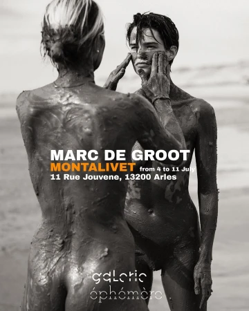 Two nude figures covered in mud pose on a beach in this high-contrast black and white promotional image for an art exhibition.