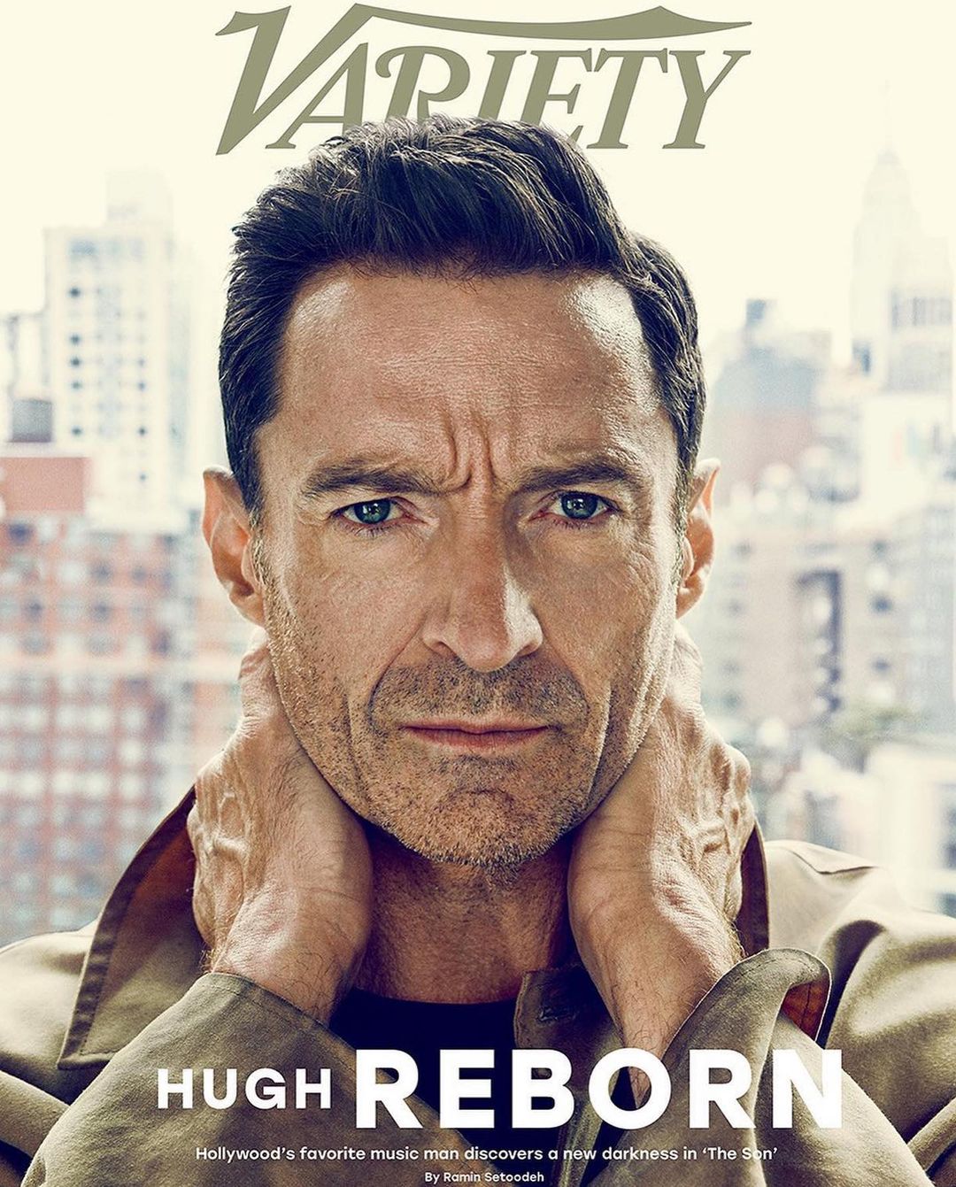 Close-up of Hugh Jackman on the cover of Variety magazine, wearing a tan coat, with an urban background visible through a window.