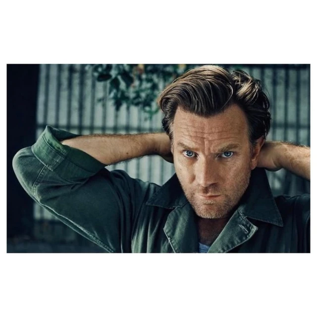 Close-up portrait of a handsome adult male with light hair, looking directly at the camera, wearing a green collared shirt.
