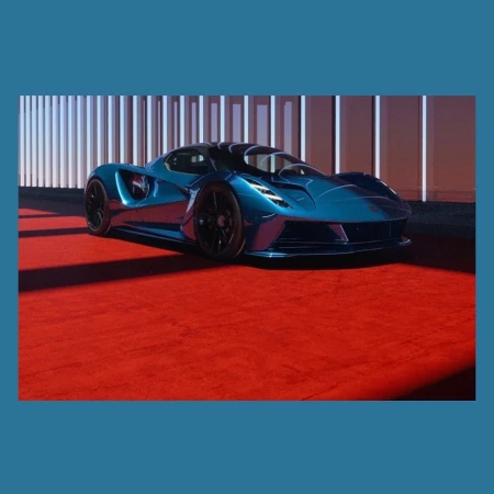 Sleek, blue sportscar with black wheels parked on a red carpet in front of a modern architectural backdrop with white columns.