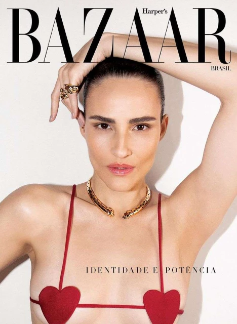 Harper's Bazaar cover featuring a tanned woman in a red heart-shaped top and gold snake necklace, striking a pose against a plain white backdrop.
