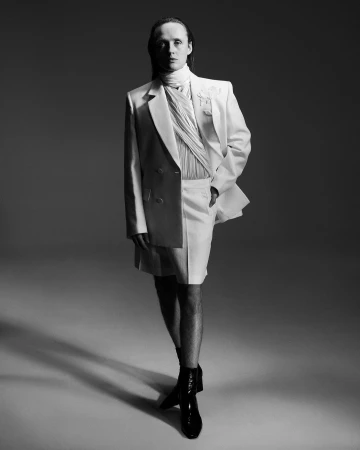 Monochrome portrait of a man in a white suit jacket and shorts by photographer Marcin Kempski