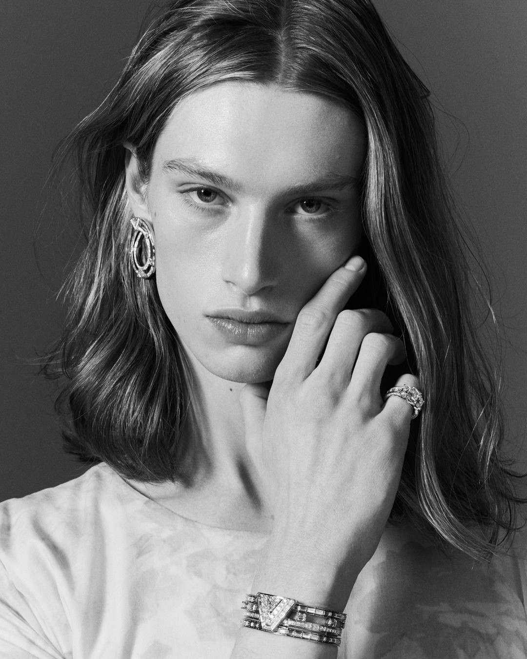 Monochrome portrait of a long-haired model wearing sculptural jewellery by photographer Marcin Kempski
