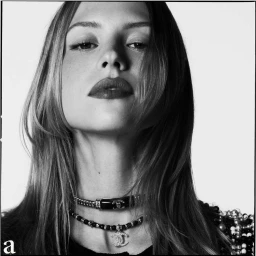 Close-up portrait of a woman wearing layered designer choker necklaces against a plain white background shot in Paris.