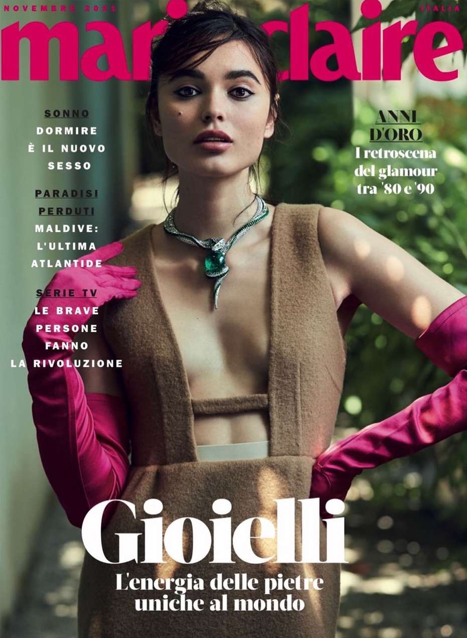 Marie Claire magazine cover featuring a woman wearing a brown dress and a serpentine emerald necklace, posing indoors with lush greenery background.