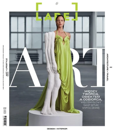 Magazine cover featuring a woman in a green dress posing with a sculpture in a minimalist indoor setting with natural lighting.