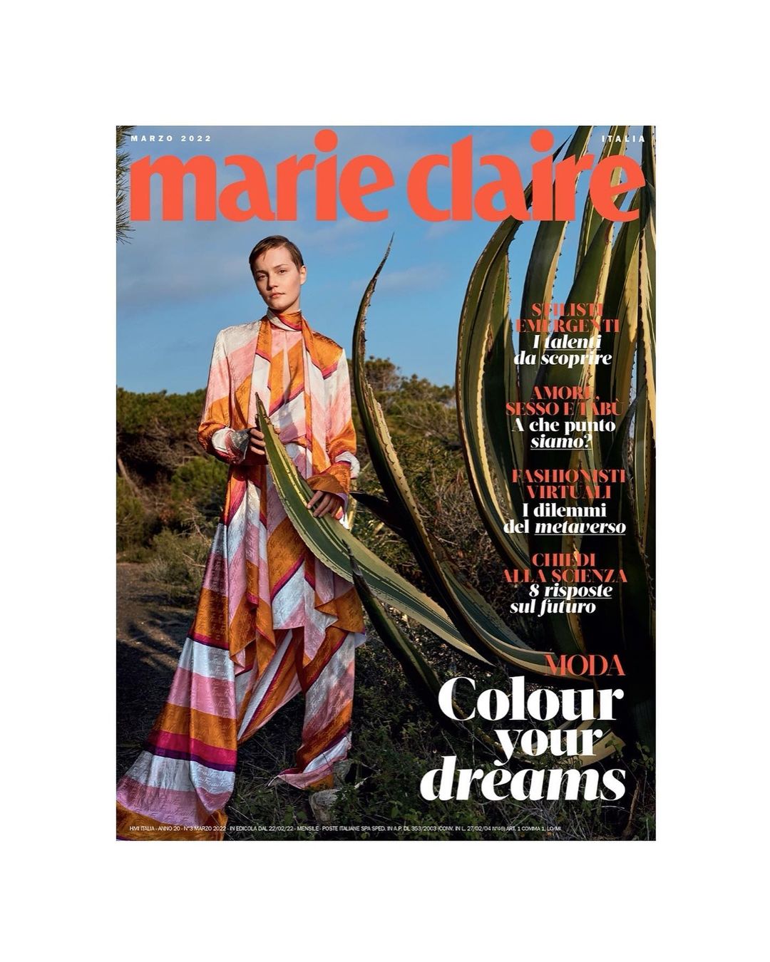 Marie Claire Italia cover features a model in a patterned silk jumpsuit, set against an outdoor landscape with tall green plants.