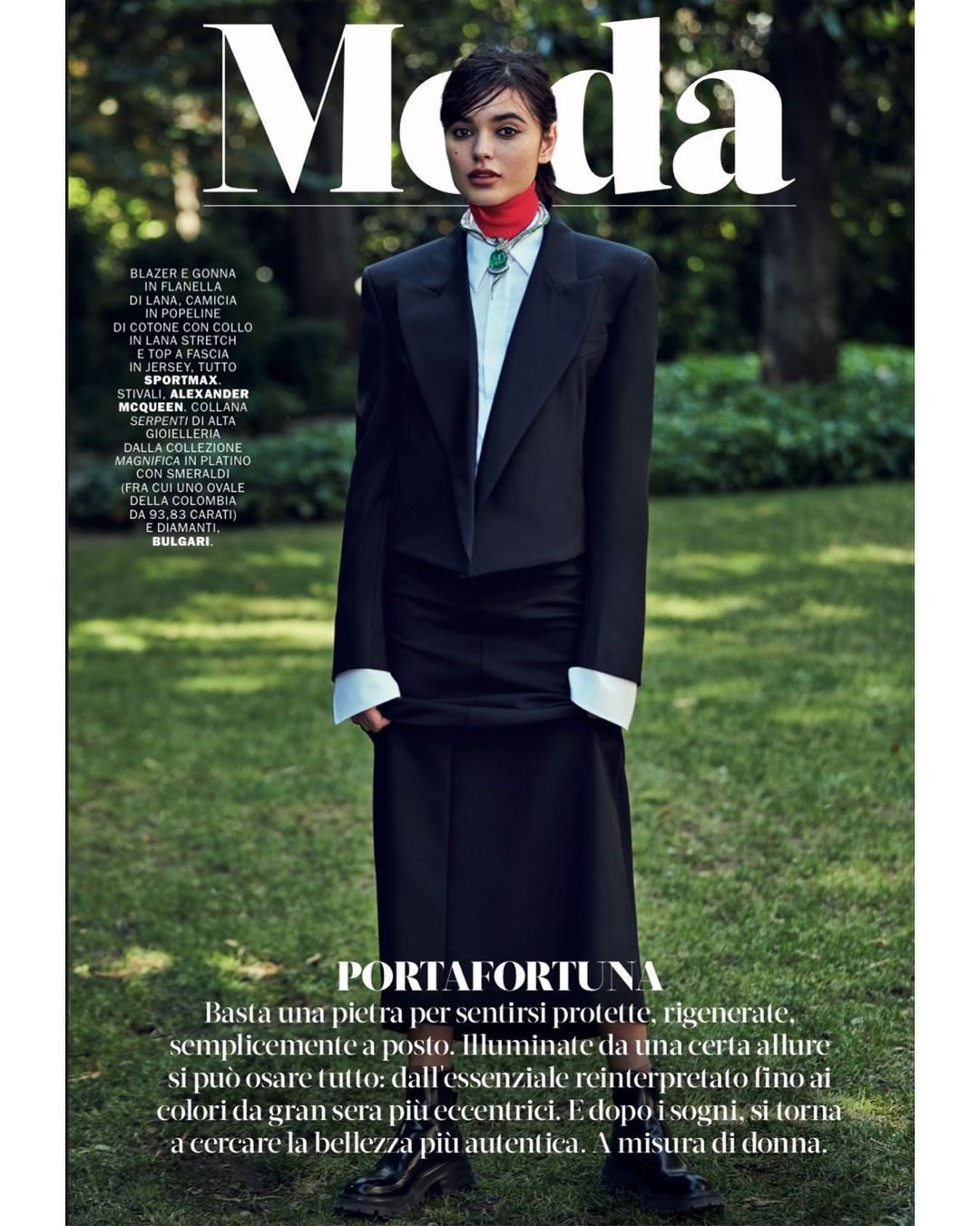 Magazine cover features a woman in a dark blazer and long skirt, set against a natural background with green grass and trees.