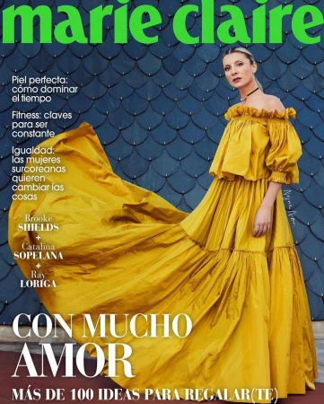 Marie Claire magazine cover featuring a model in a flowing yellow dress, green masthead, and cover text in Spanish on a textured blue background.