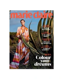 Model wearing a patterned silk jumpsuit holding a large agave leaf outdoors, photographed by Marcin Tyszka.