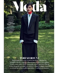 Model in black blazer and midi skirt standing on grass in a park, photographed by Marcin Tyszka.