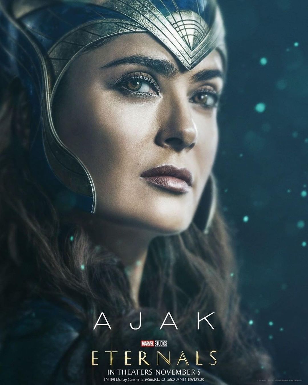 Portrait of Salma Hayek as Ajak in Marvel Studios' Eternals movie poster, close-up with blue and silver headpiece, dark teal background.