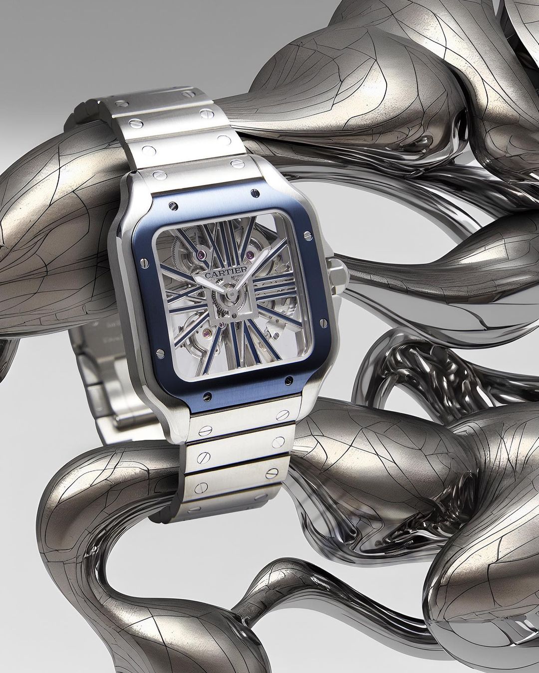 Luxury silver Cartier watch on a silvery sculptural form against a white backdrop, high-end product photography, wrist watch, studio shot.