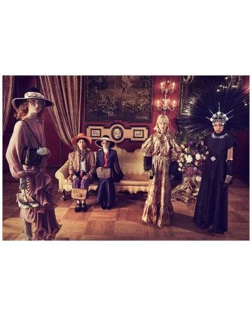 Group of five people in vintage-inspired fashion, posing in an ornate indoor setting with floral arrangements and antique furniture.