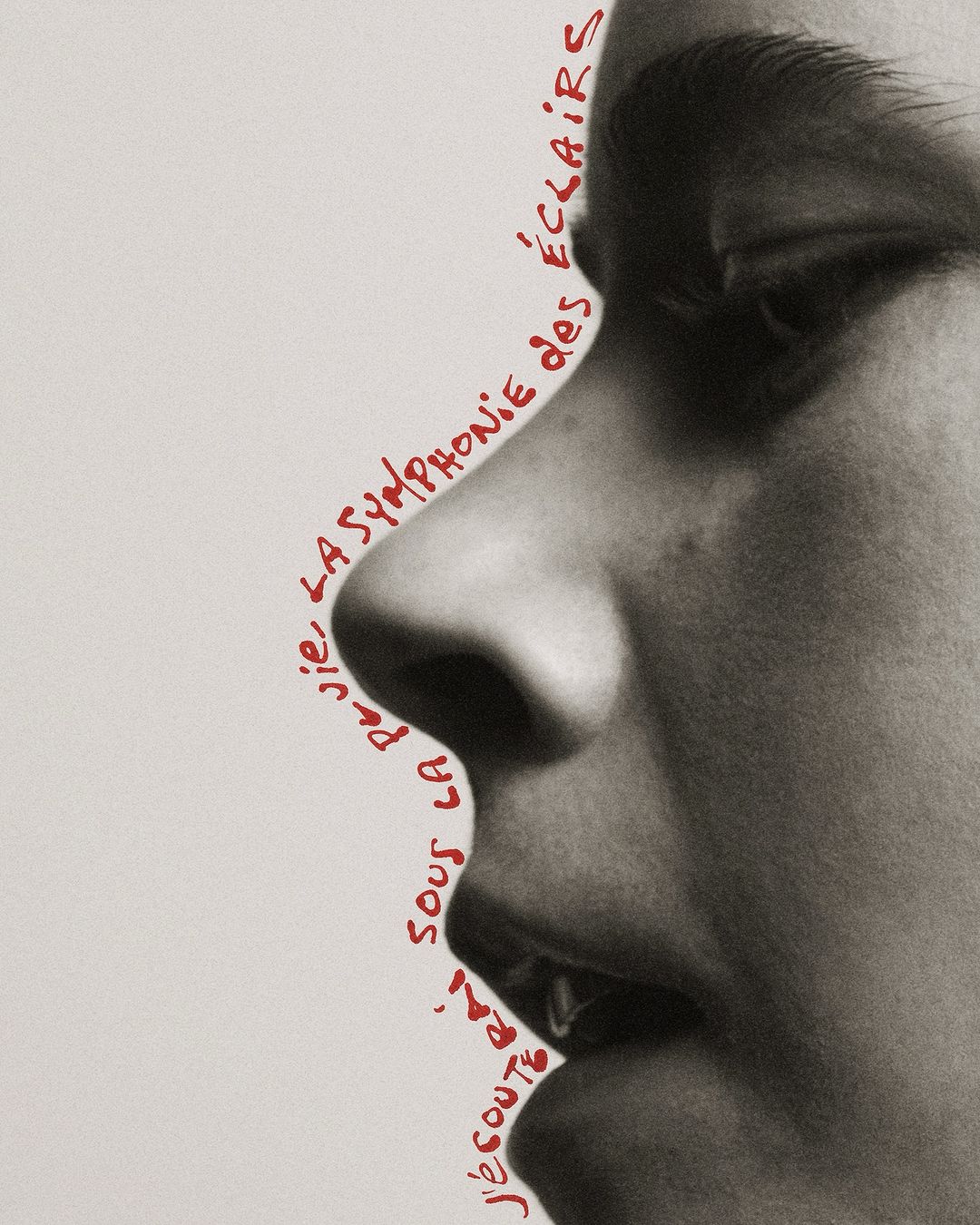 Close-up profile of a person's face with red handwritten text art outlining the contours on a neutral background in a studio.
