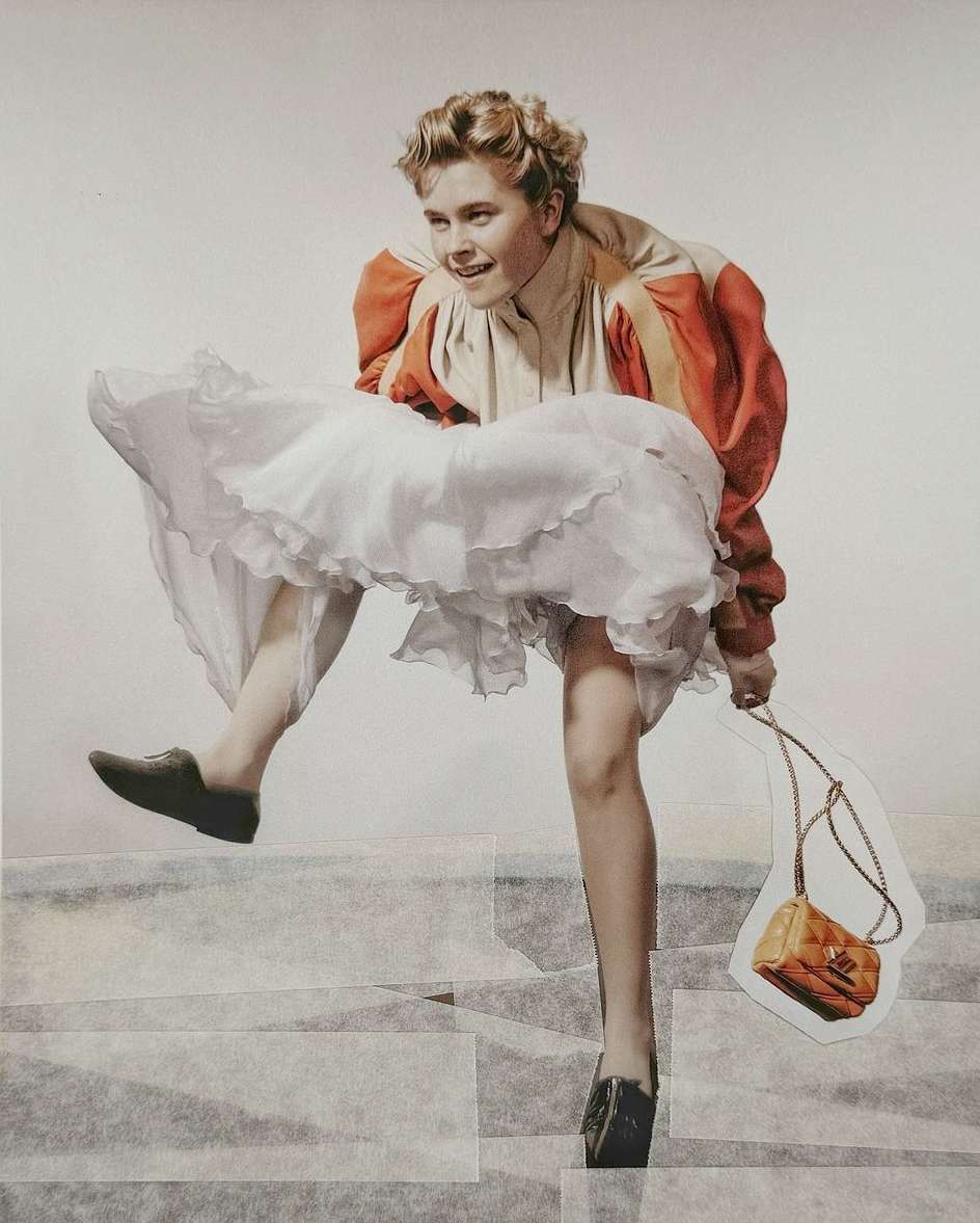 Adult woman in a tan and orange jacket and white dress, descending a set of gray tile stairs while holding a tan purse.