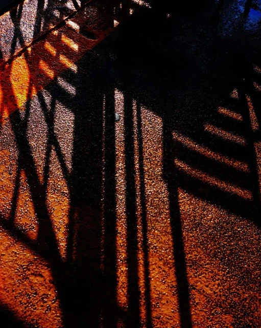 Abstract composition featuring linear shadows cast across a surface, with a dark color palette and gradient effect.