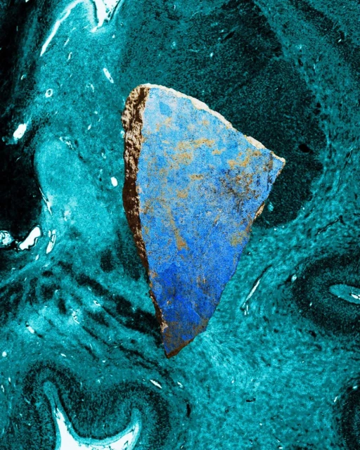 Abstract digital art image features a blue and brown stone-like object against a fluid, teal and black marbled background for an otherworldly feel.