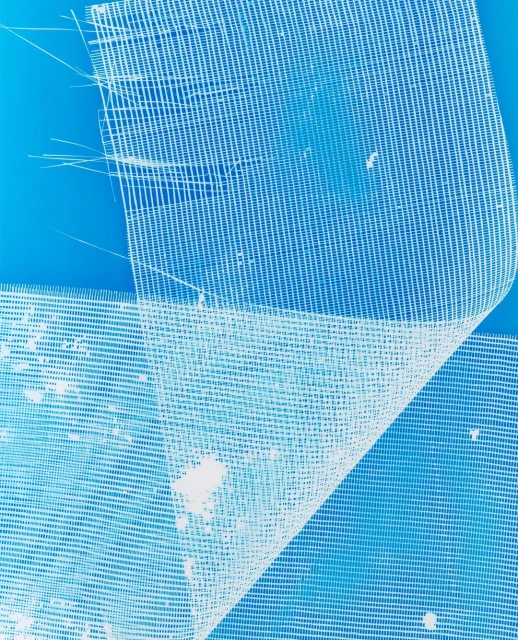 Close-up of white, sheer fabric featuring a loose grid pattern against a bright blue background, creating a clean and minimalist textile design.