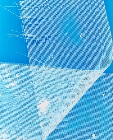 Close-up of white, sheer fabric featuring a loose grid pattern against a bright blue background, creating a clean and minimalist textile design.