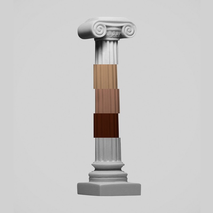 Grey stone column with sections of different skin tones stacked in the middle on a light grey background in a studio shot.