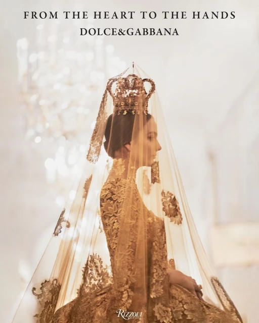 Profile shot of a woman with elaborate gold headwear and gown, lace veil, posing in front of a blurred light background. Fashion editorial.