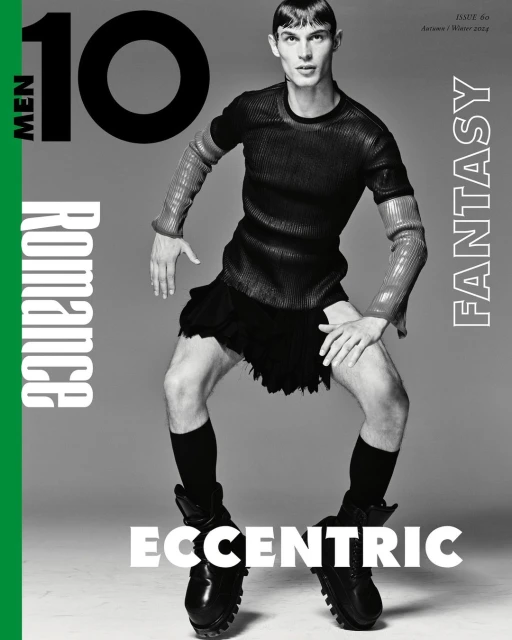 Magazine cover featuring male model in high fashion, wearing a black top, skirt, socks, and boots, set against a grey background.
