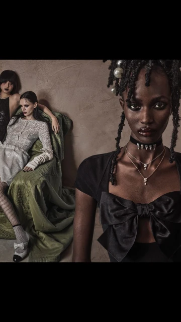Three fashionably dressed women pose in front of a textured background. The primary subject is an African American woman wearing necklaces.