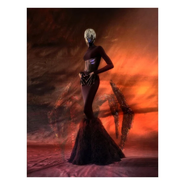 Elegant woman in a maroon gown with a dramatic feathered skirt poses against a swirling orange and black abstract background in a studio setting.