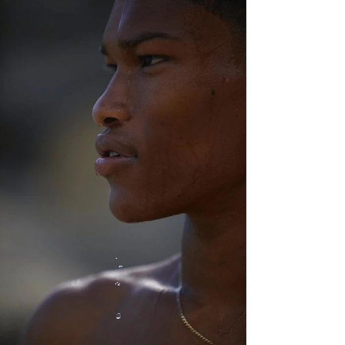 Close-up profile portrait of a man with wet skin and water droplets dripping from his chin by Marie Schmidt